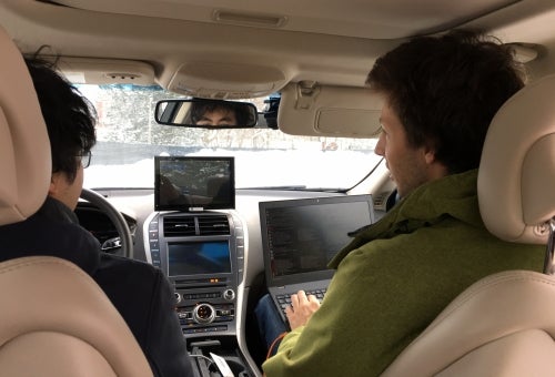 Graduate student researchers Carlos Wang (left) and Ian Colwell track operation of the Renesas sedan during testing in Stratford