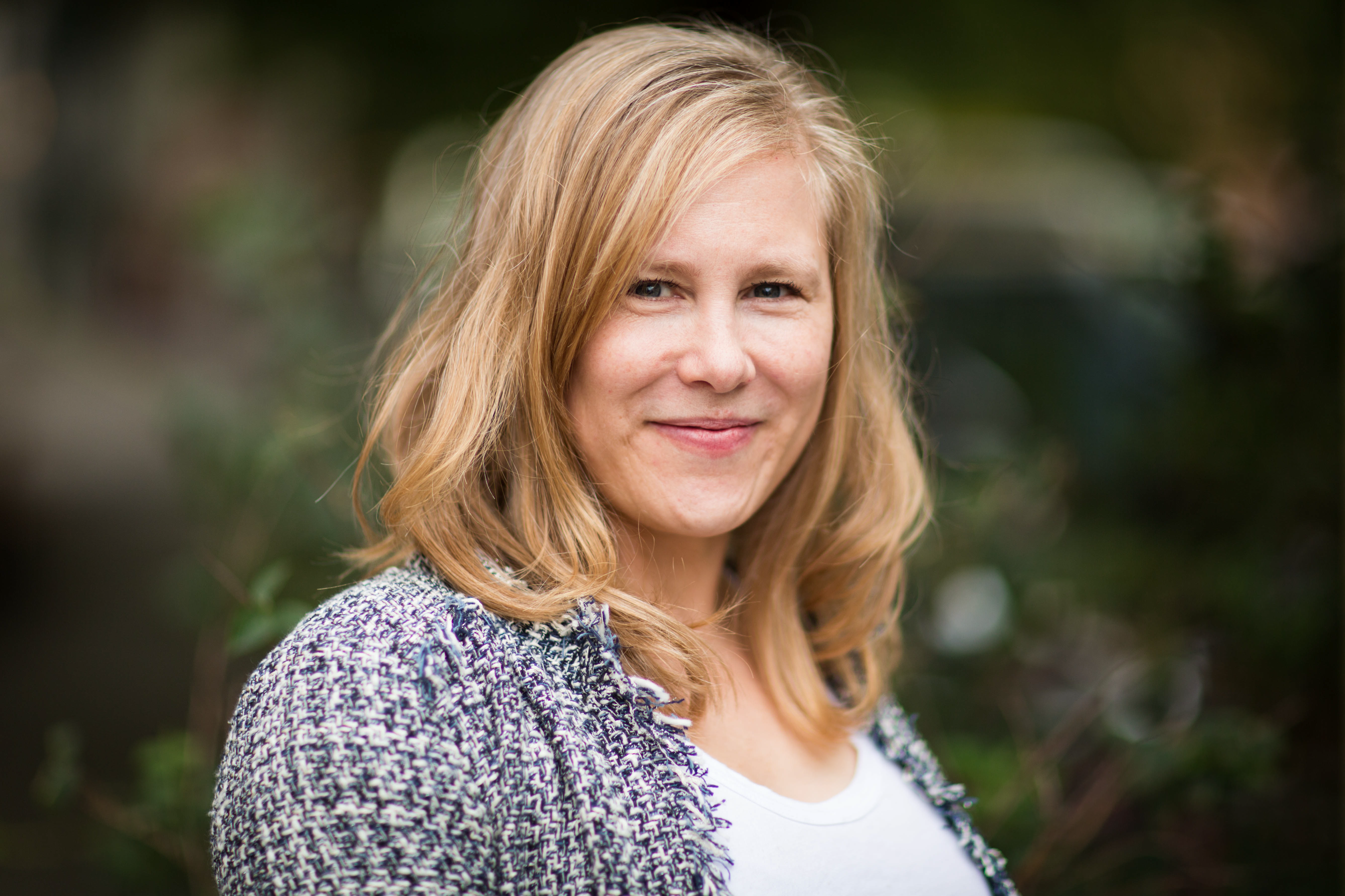 Headshot: Person with long blonde hair and a blue knit cardigan