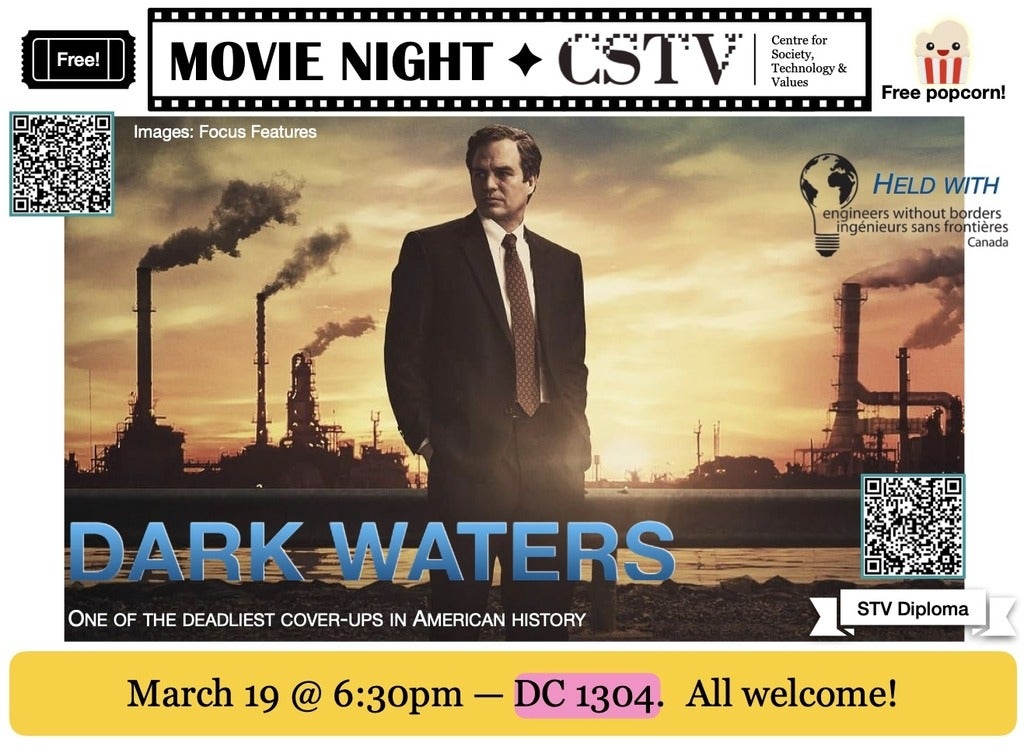 Man in a dark suit stands in front of a river behind which tall smoke stacks spew pollutants into a red sky