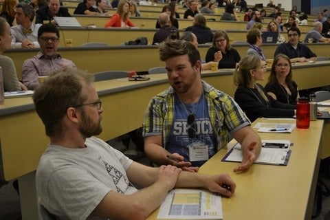 Two participants in discussion at keynote talk for the Cultivating Curiosity in Teaching and Learning conference