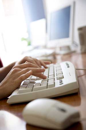 Person typing on a computer keyboard.