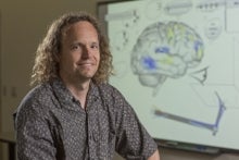 Chris Eliasmith in front of brain picture