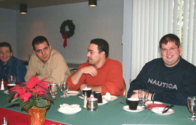 Attendees talking at Christmas lunch 2003