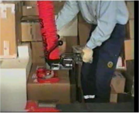 Worker using a vacuum hoist to lift boxes 