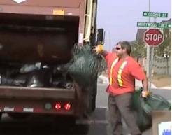 Man placing garbage bags into truck