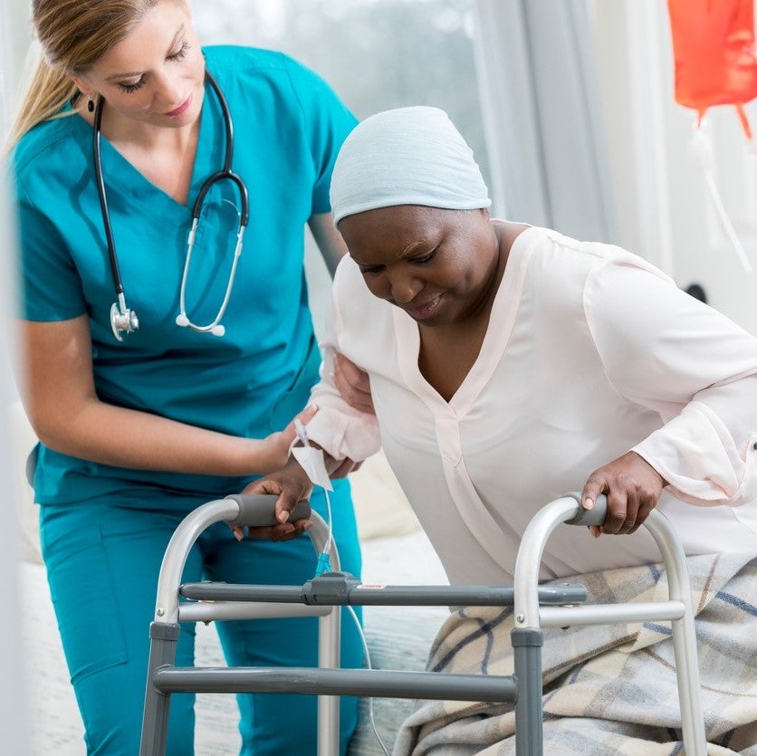 A nurse assisting a patient to stand up