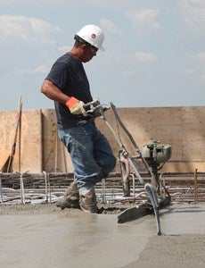 A worker using motorized screed