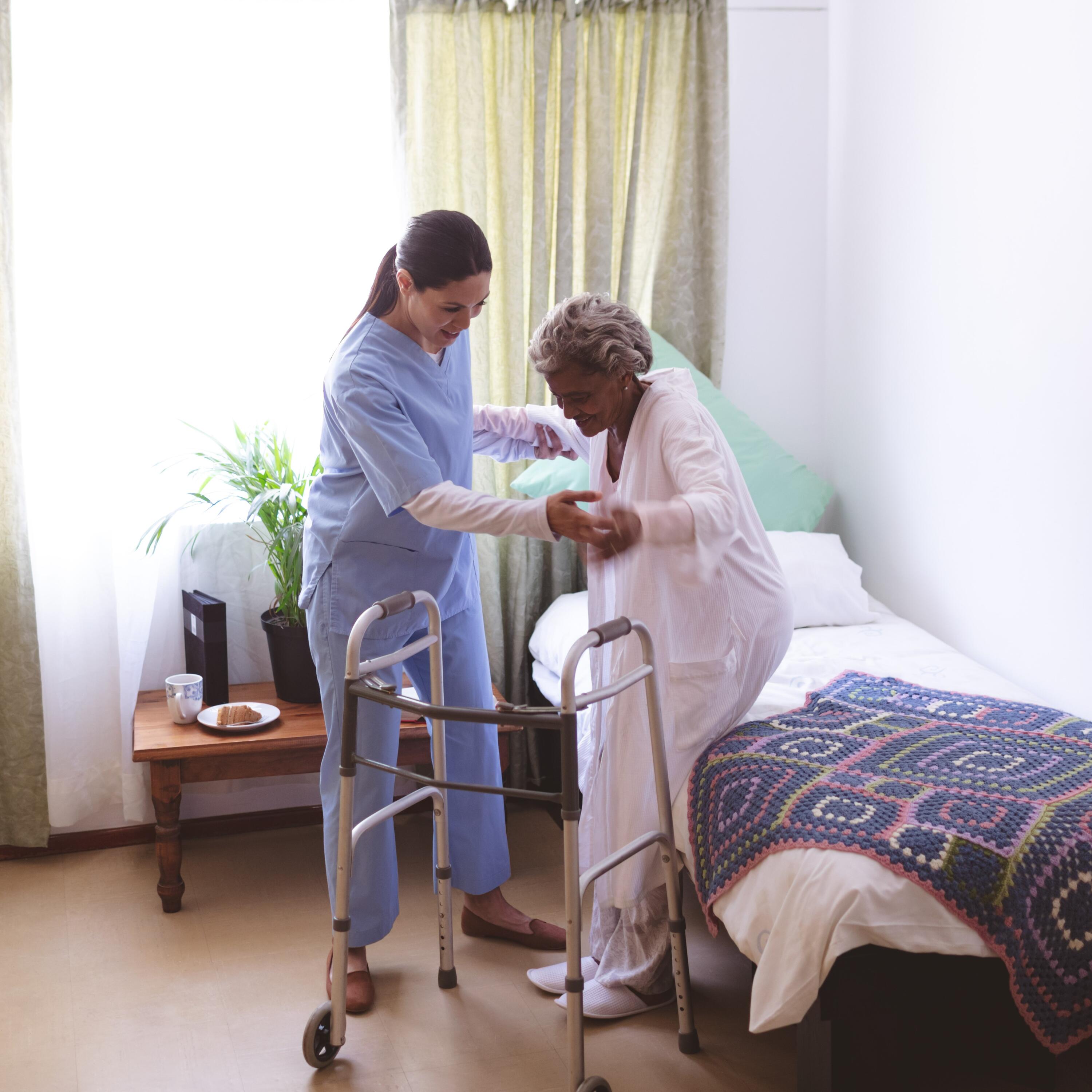 A nurse assisting a patient to stand up.