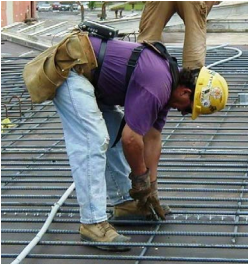 Worker tying rebar by hand