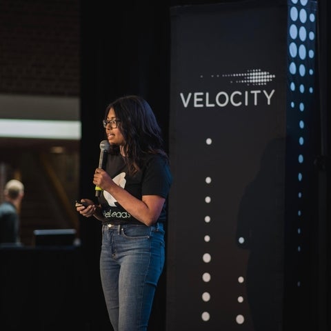 Cassie speaking on stage at Velocity funding presentation