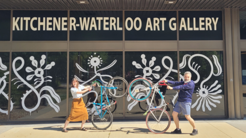Two people holding bikes