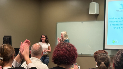 two women speaking in front of audience