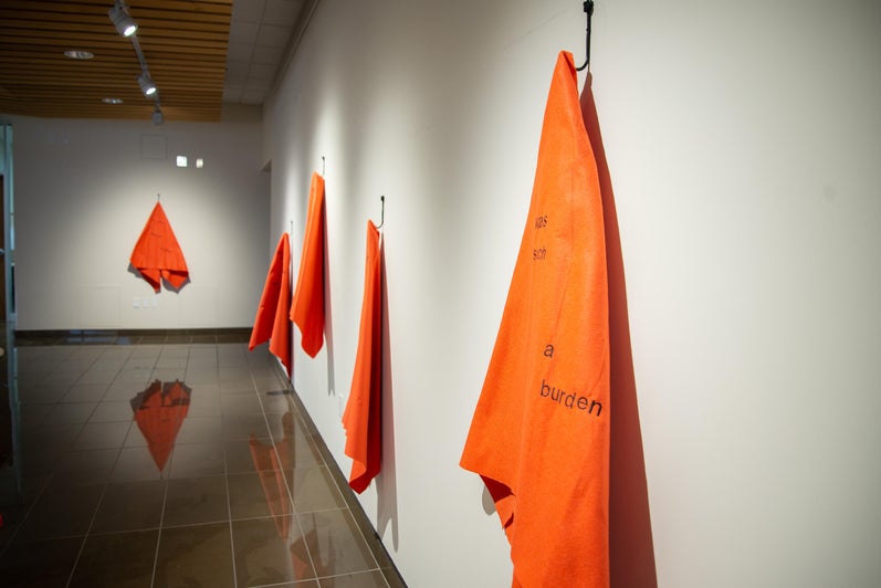 Close up image of orange blankets hanging in Grebel Gallery