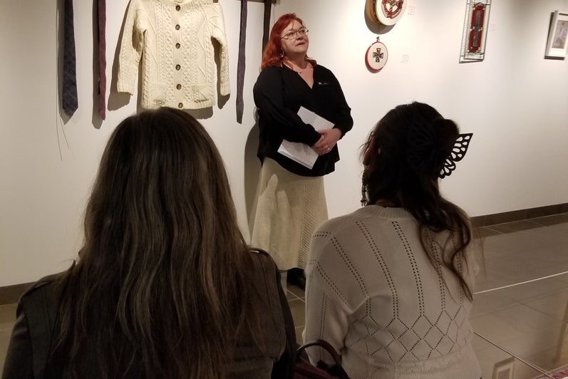 two women sitting on a bench listening to a woman speak