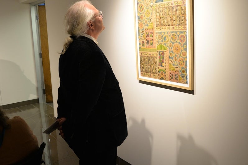 A man looking at the art work