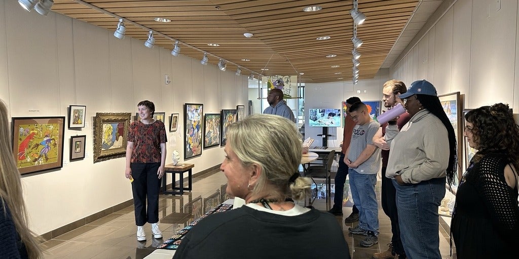 Sadie giving a tour to people around the Art is Always Conflict Gallery exhibit