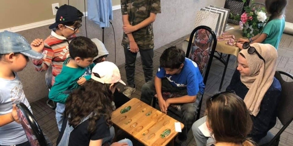 kids playing a game around a table 
