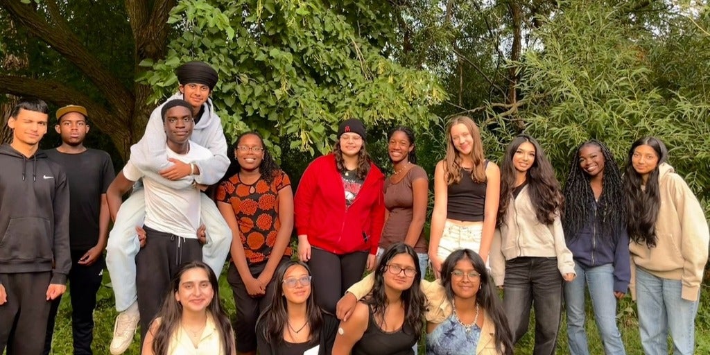 fifteen people grouped together posing for a picture