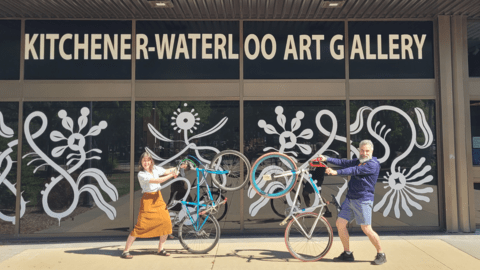 Two people holding bikes