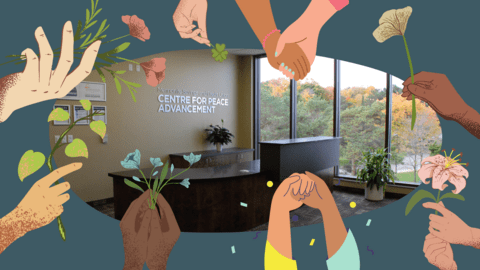 Photo of the front desk at the Centre for Peace Advancement surrounded by hands in various skin tones holding different flowers.
