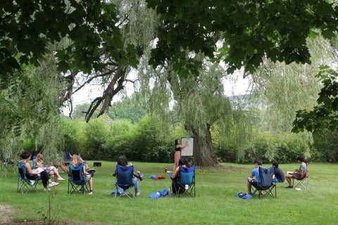 students sit under tree and learn 