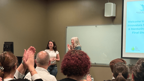 two women speaking in front of audience