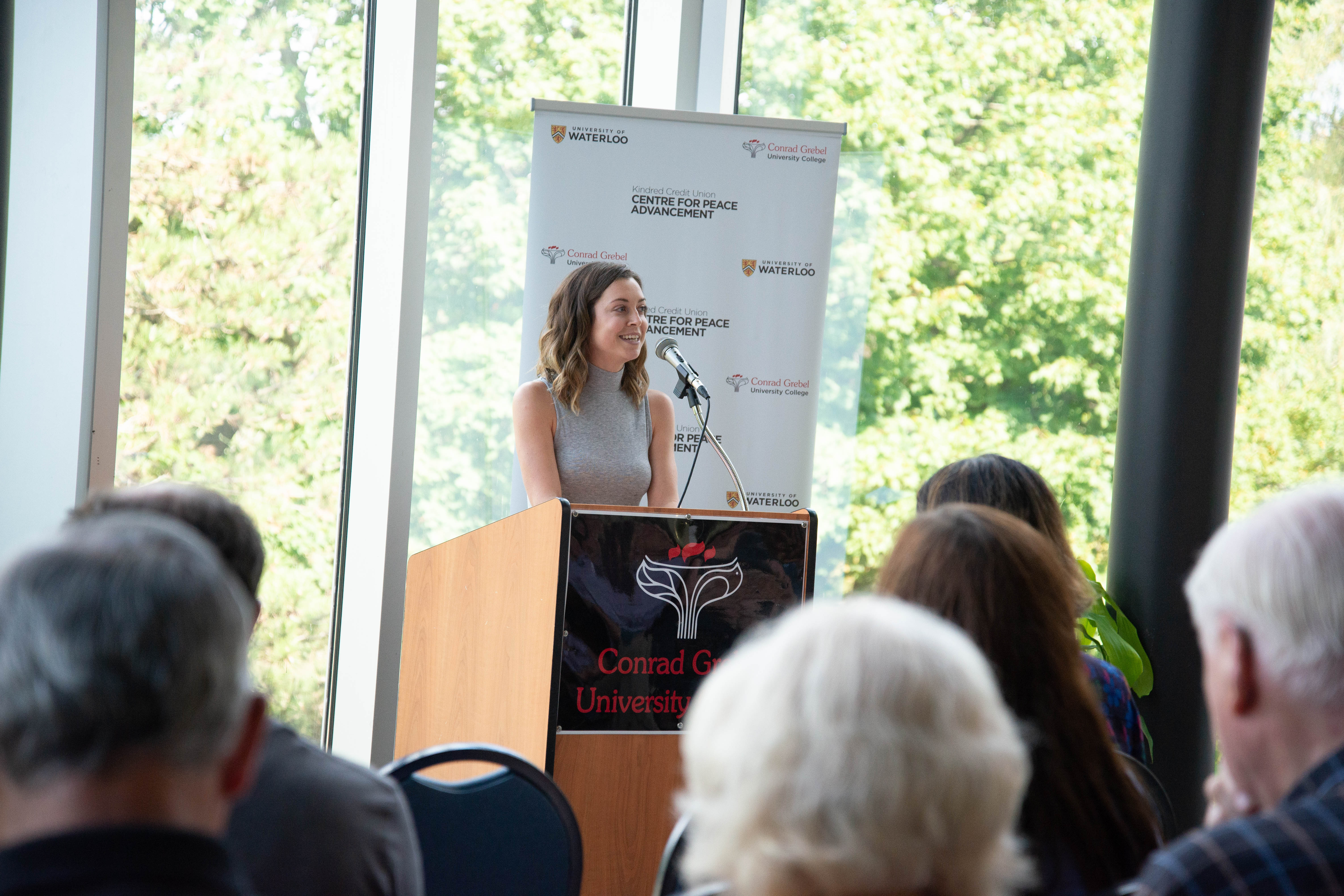 A leader of the CPA speaking to crowd of listeners in Grebel atrium