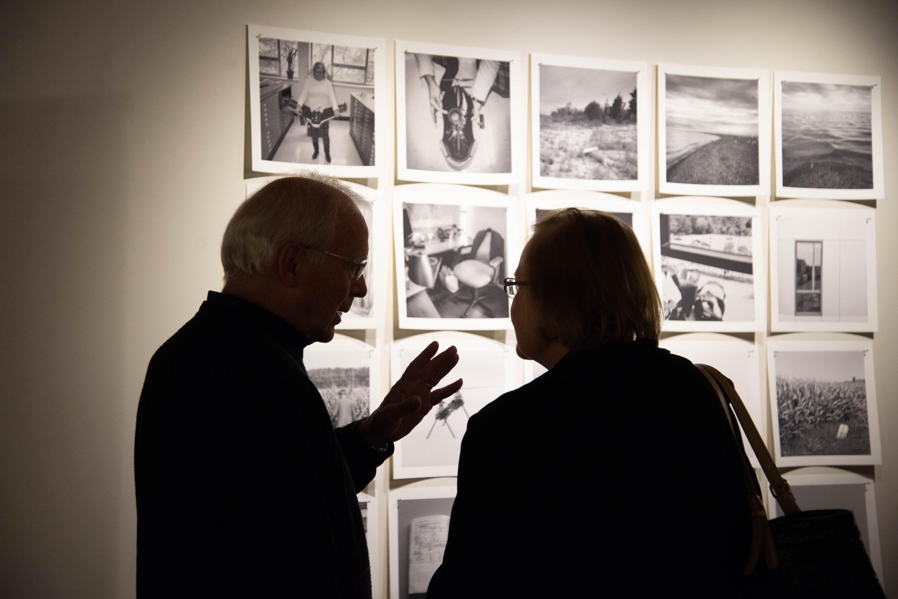 Guests chat in front of documentary photographs