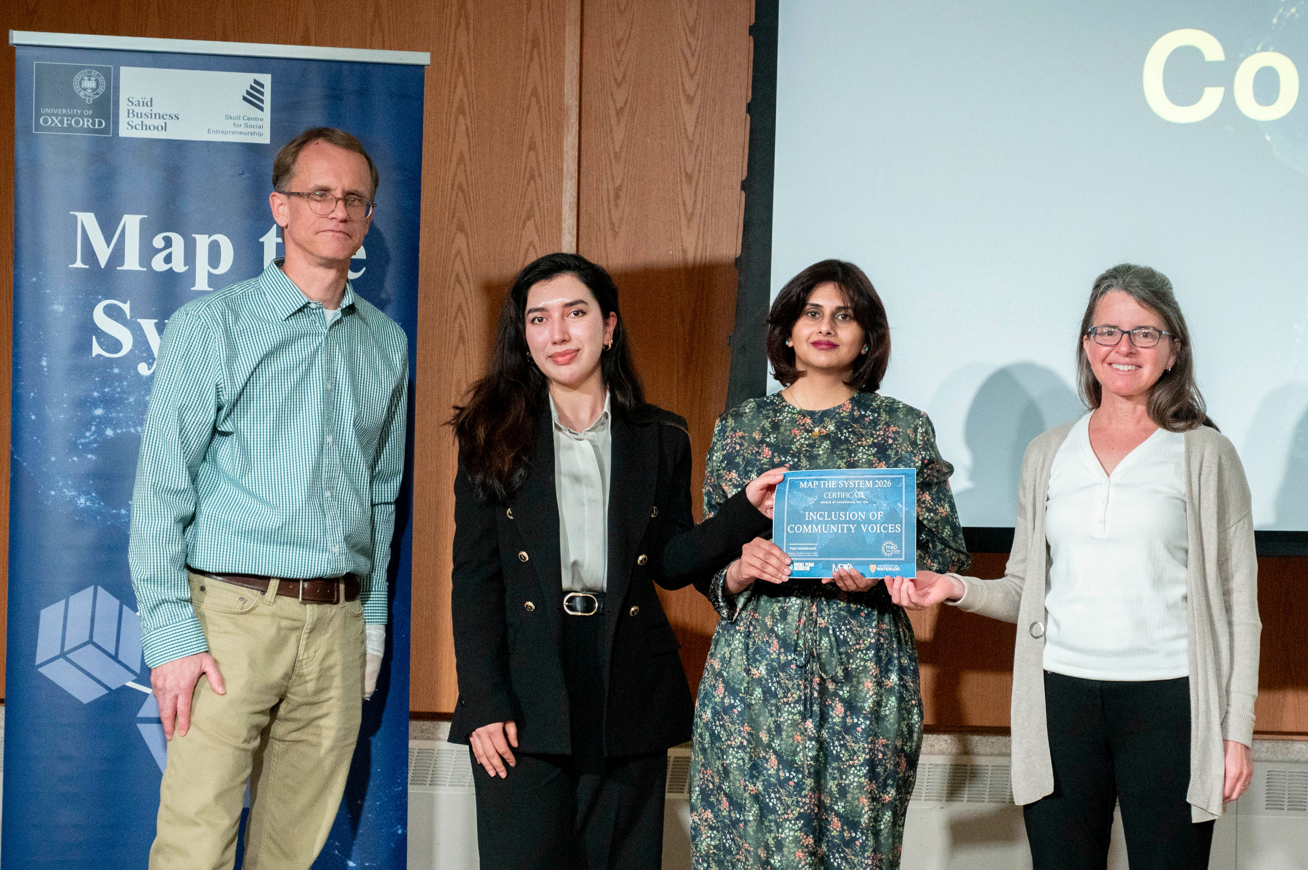 four people with a woman holding a certificate 