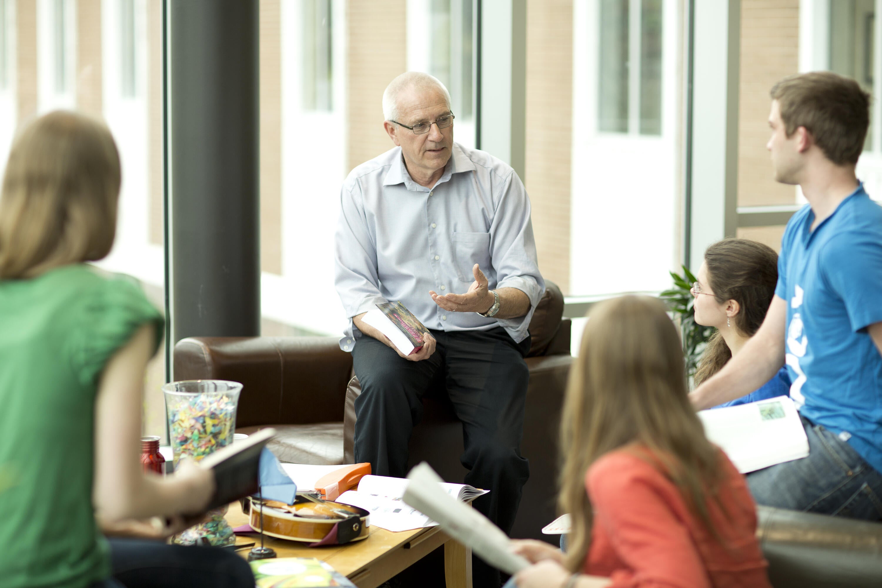 Lowell Ewert speaking with a group of students at Conrad Grebel