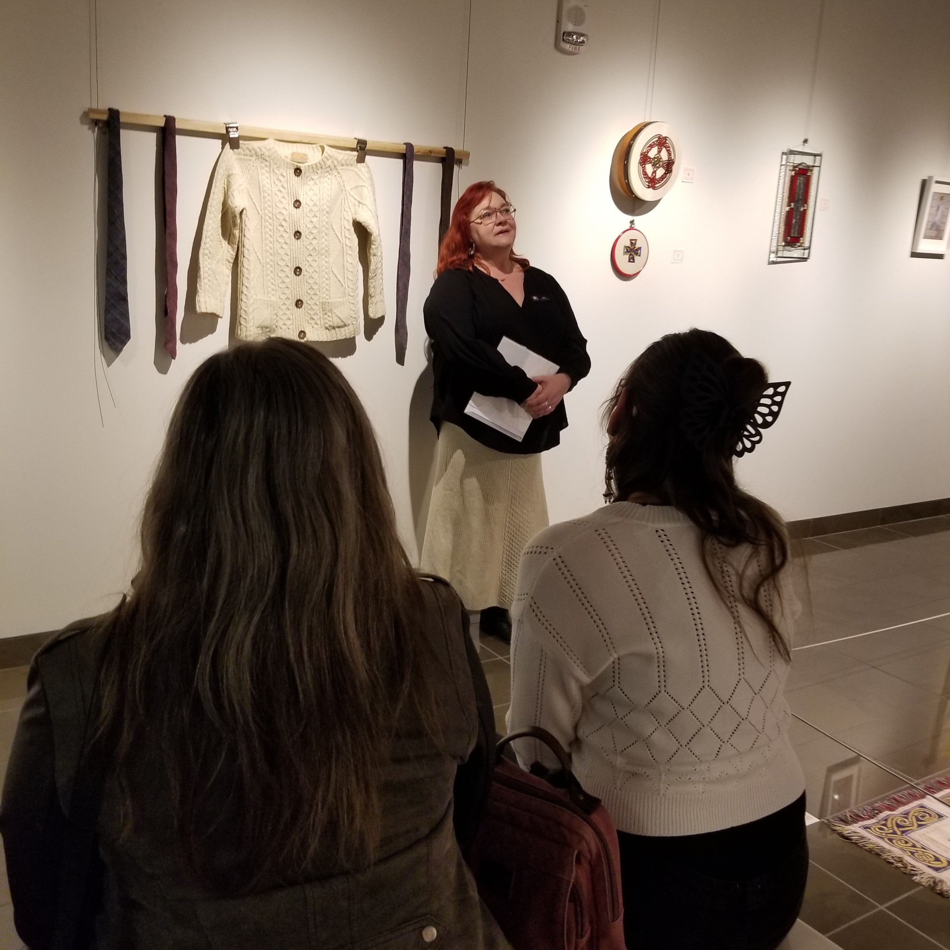 two women sitting on a bench listening to a woman speak