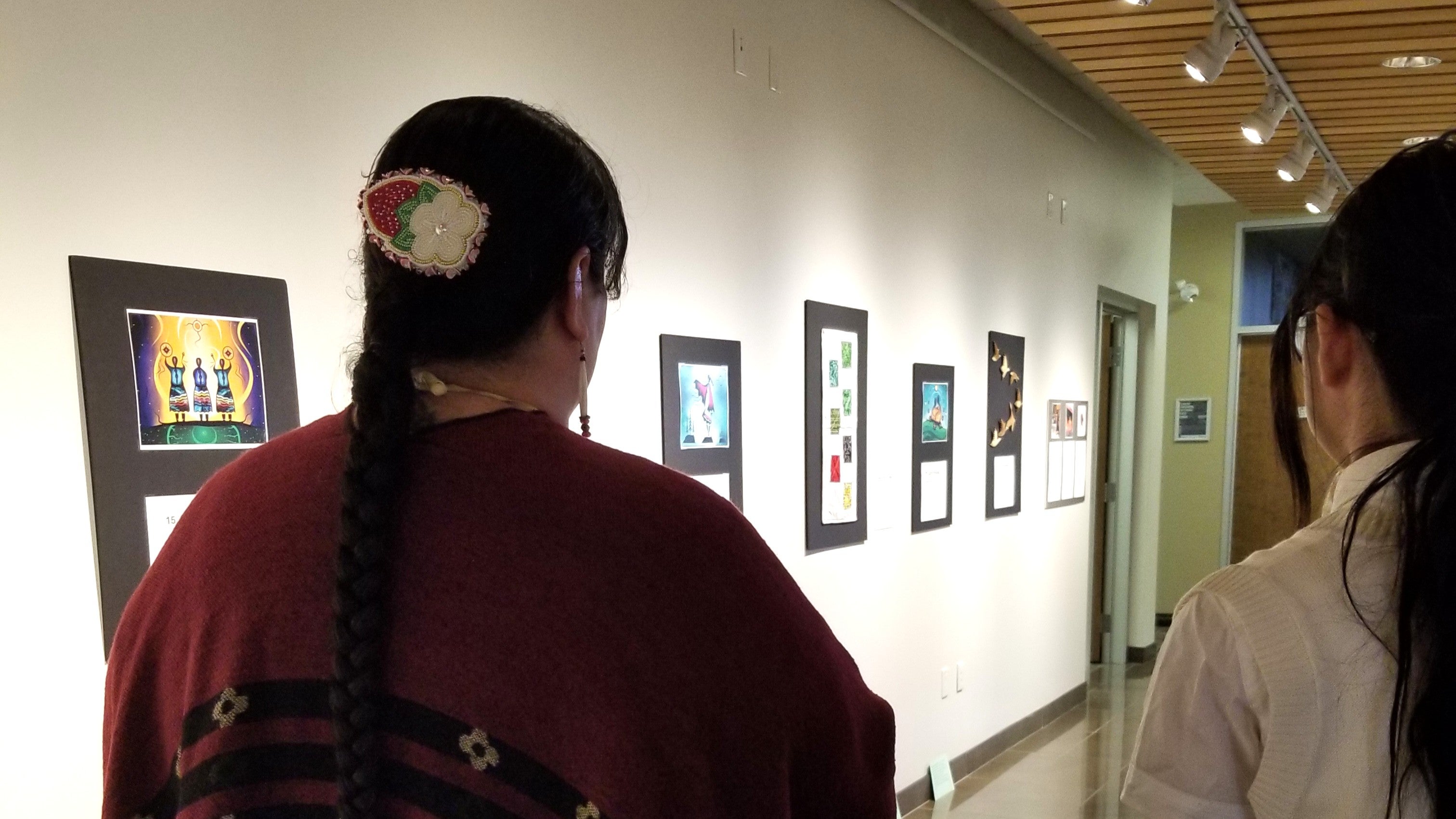 Artist Judy Ross Mack facing away from the camera towards the art