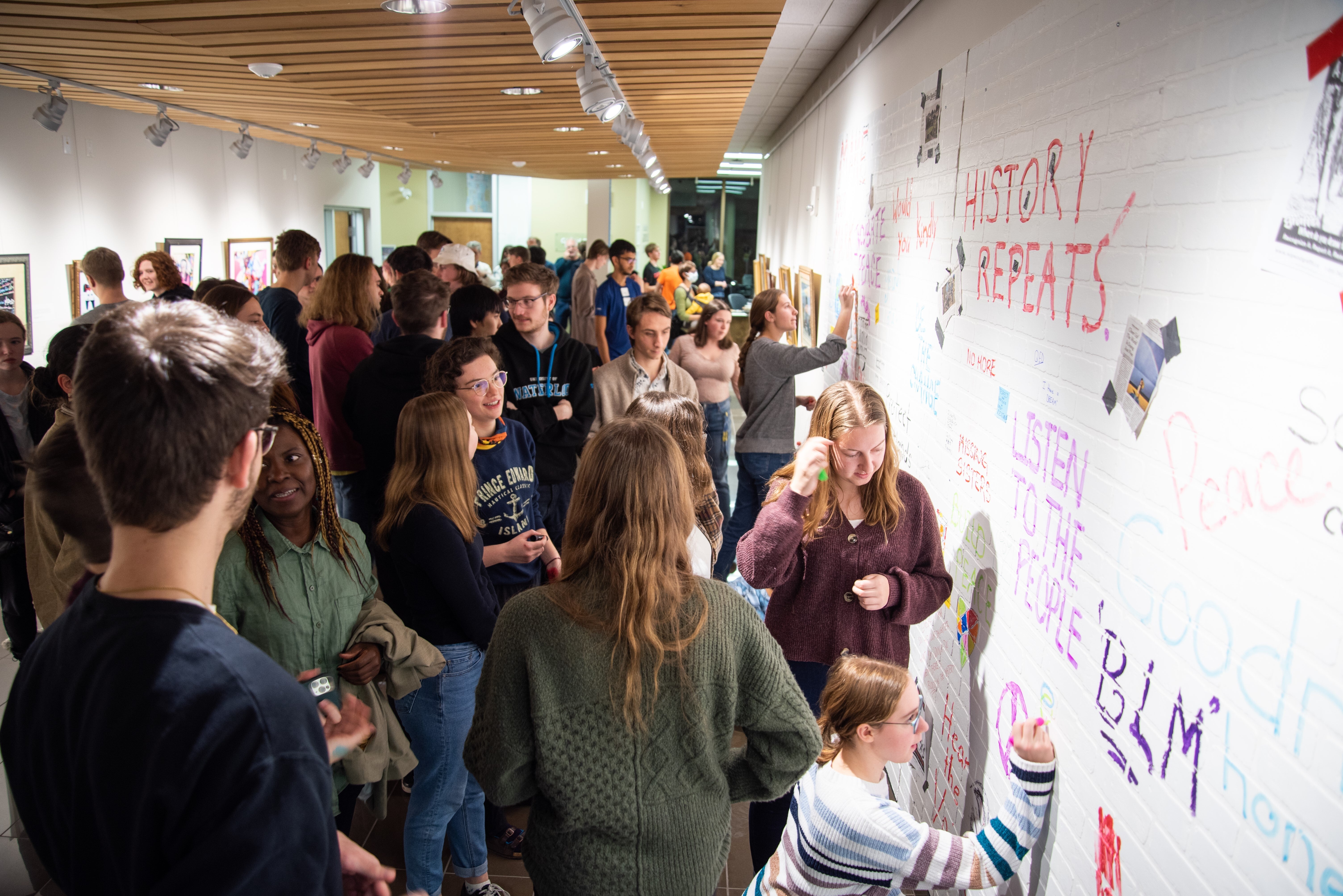 Group of students writing on the gallery wall