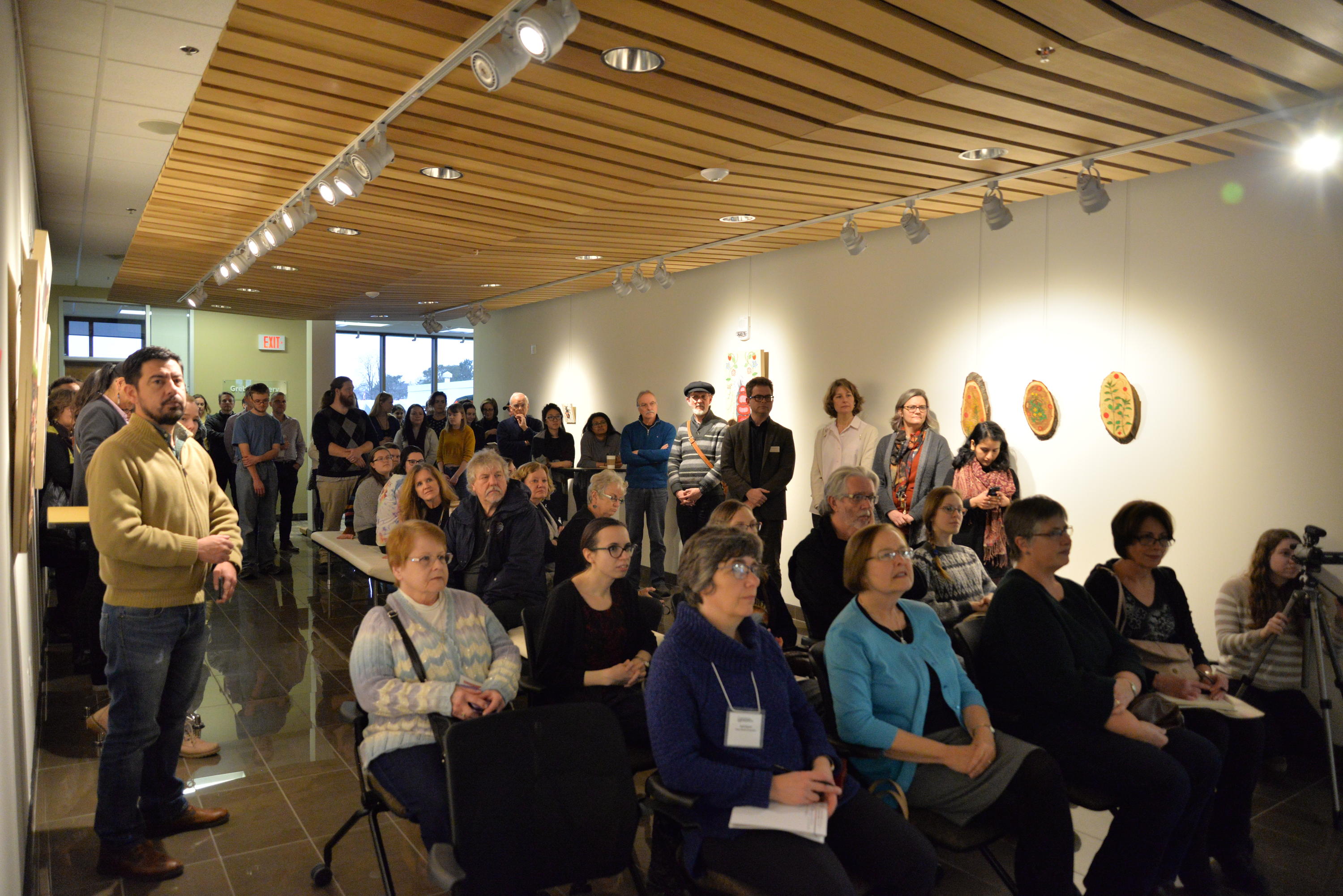 Guests listeneing attentively as Catherine Dallaire speaks about the exhibit