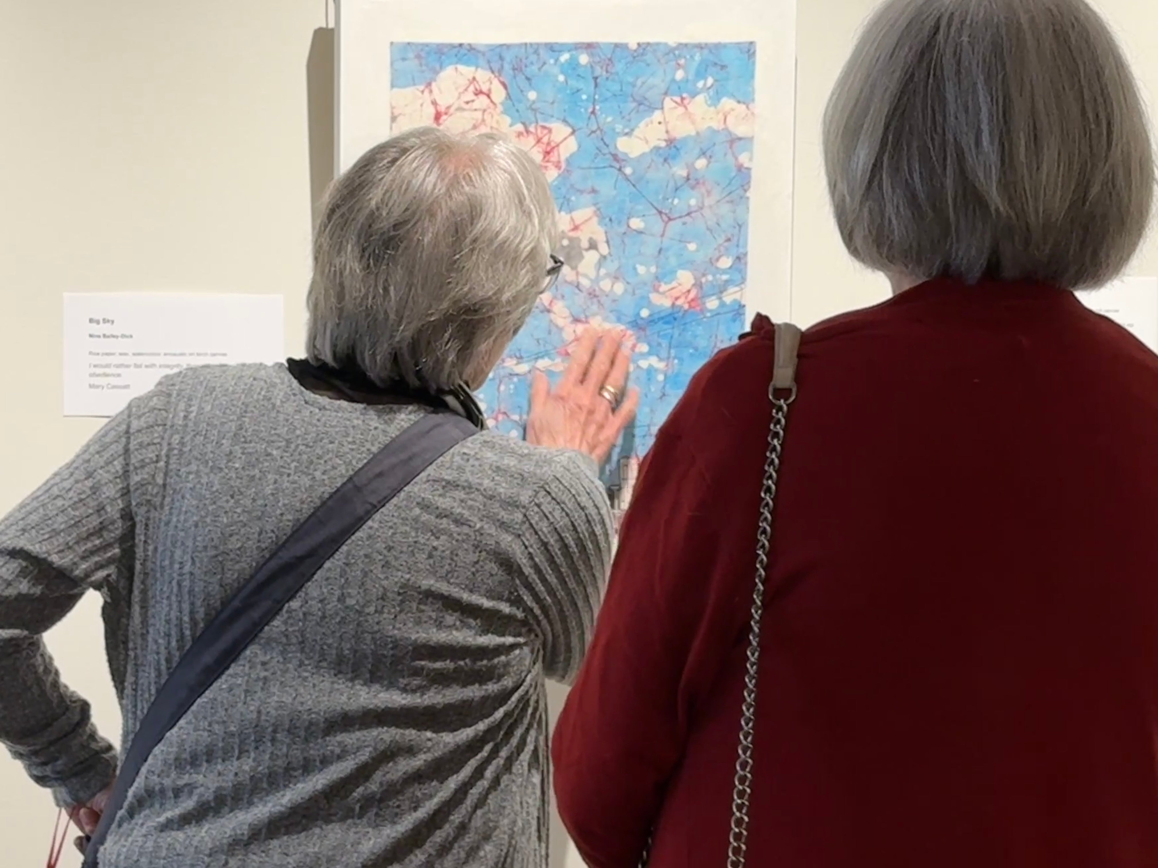two women looking at art 