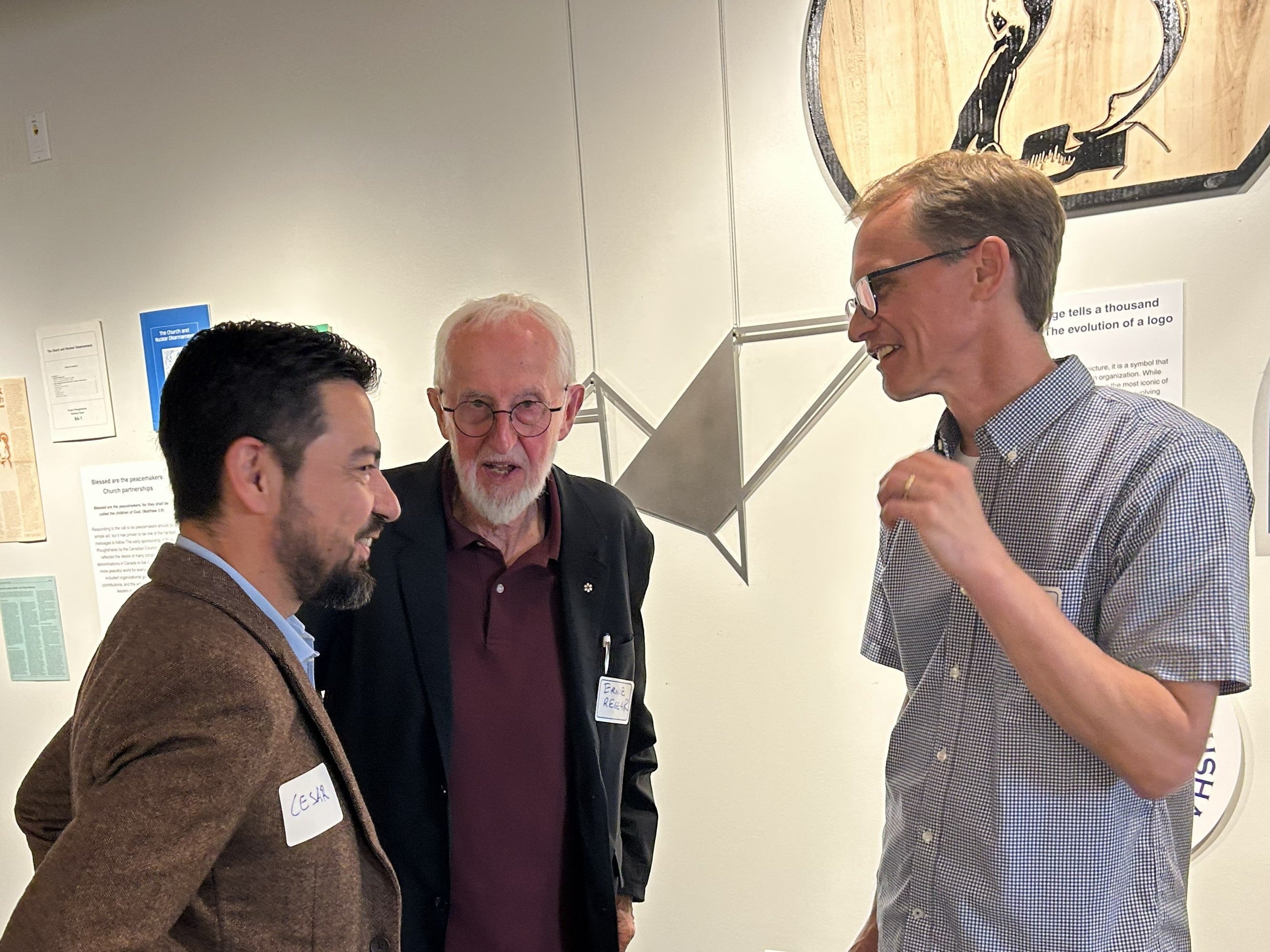 Cesar Jaramillo, Ernie Regehr and Paul Heidebrecht telling stories to one another at the Ploughshares exhibit launch