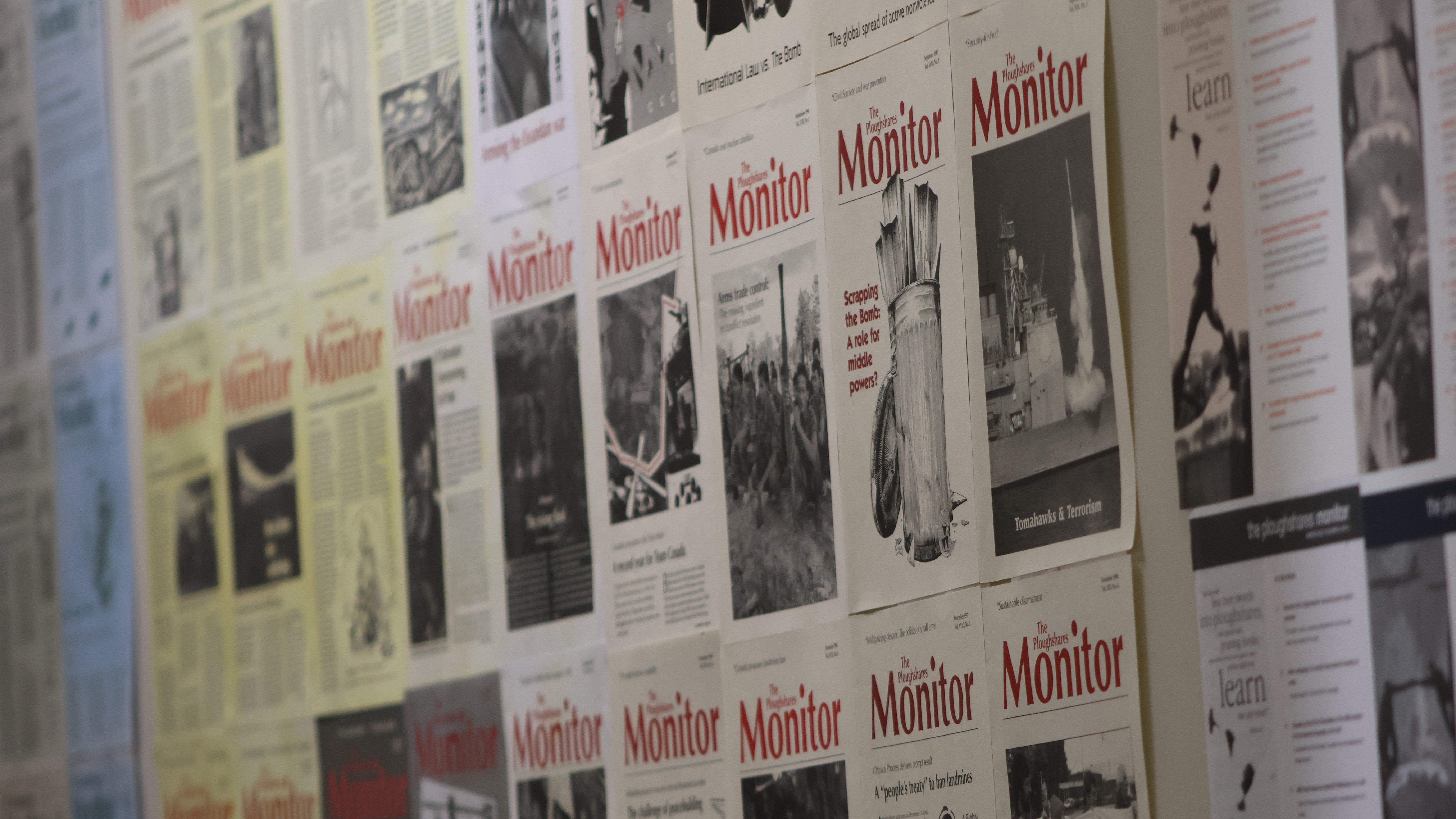 A wall of past Ploughshares Monitor magazine covers