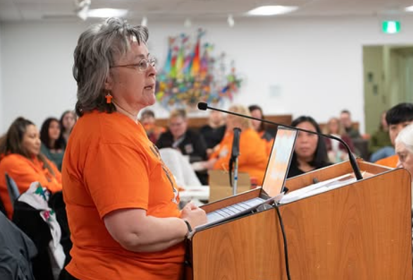 woman speaking in front of a podium