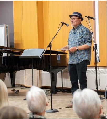 man speaking to a group using a mic