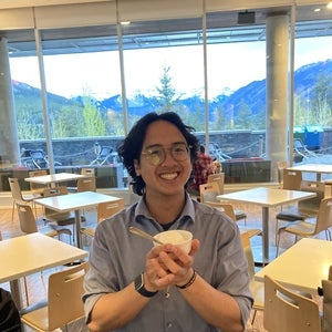 Gabriel holding an ice-cream cup while smiling 
