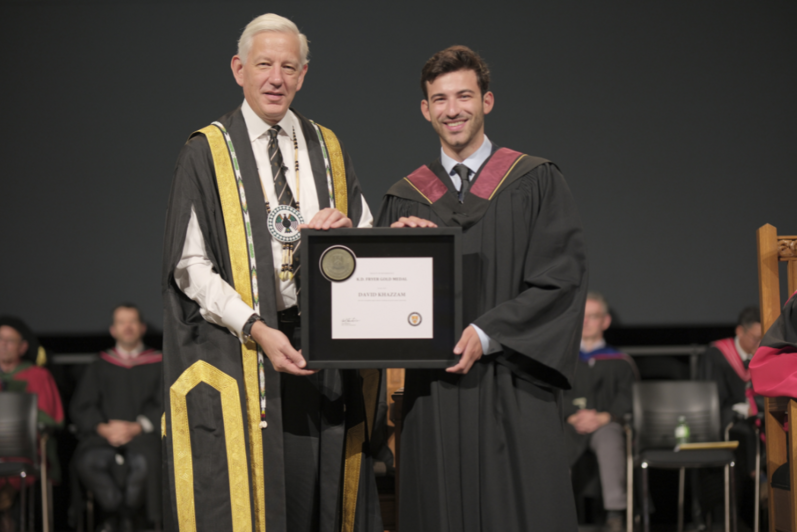 Dominic Barton and student holding diploma