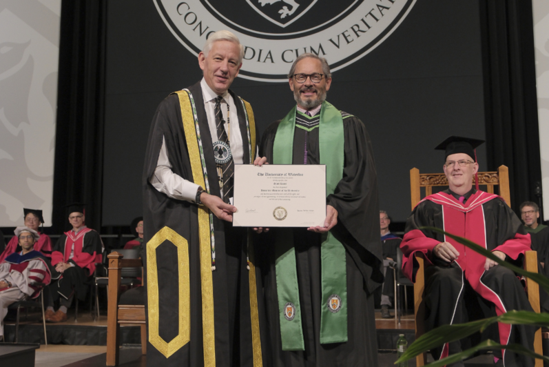 Dominic Barton and student holding diploma