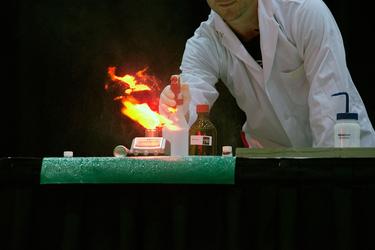 Man giving chemistry demonstration with flame.