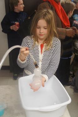 Student creating bubbles from a hose.