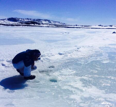 Chaim Andersen going to imittak (fetch water), drinking surface freshwater out of a tin bowl on the sea ice.