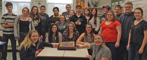 Students from Hants North Rural High School from Kennetcook, Nova Scotia posting with a mole day cake