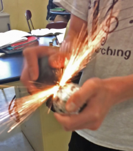 Student starting a spark between two rocks.