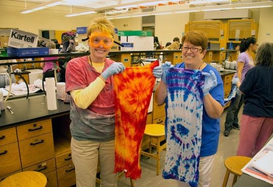 Two women holding tie-dyed cloth.