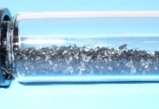 vial with dark metallic material 