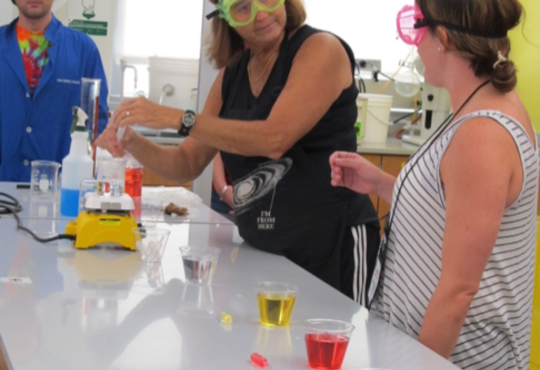 Penny Sconzo showing a demo with chemistry equipment and coloured liquids.